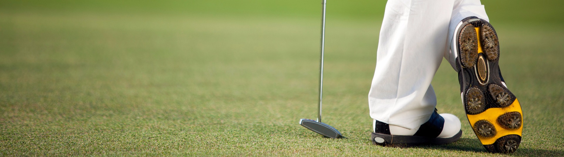 Golfer leaning on club on golf course